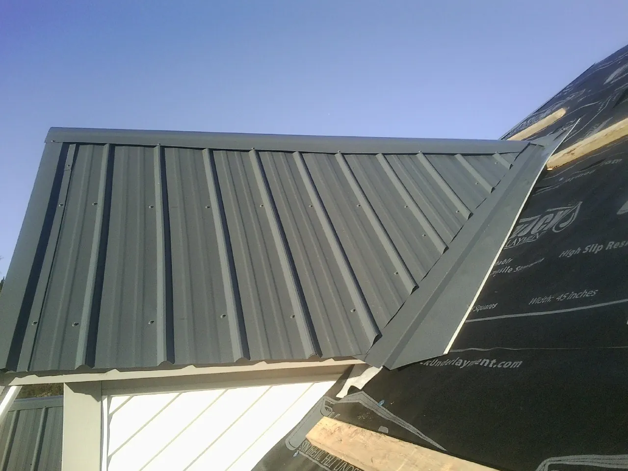 Gray metal roof panels going on over a garage gable in Boyertown