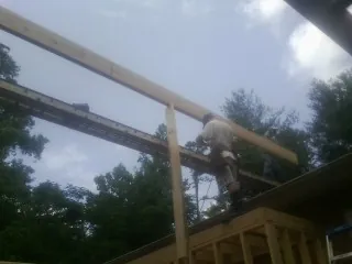 Carpenter setting a ridge beam over a new addition frame — Ice Dam Removal by Roofing Brothers in Boyertown
