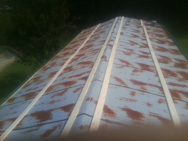 Rusted metal roof panels with new wood purlins before replacement — Storm Damage Roof Repair in Boyertown by Roofing Brothers