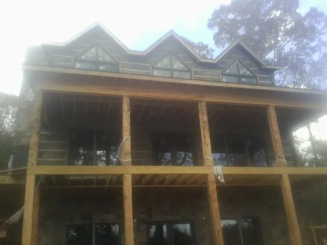 Dormers and porch framing on a large log home under construction — Roof Coating work by our crew in Boyertown