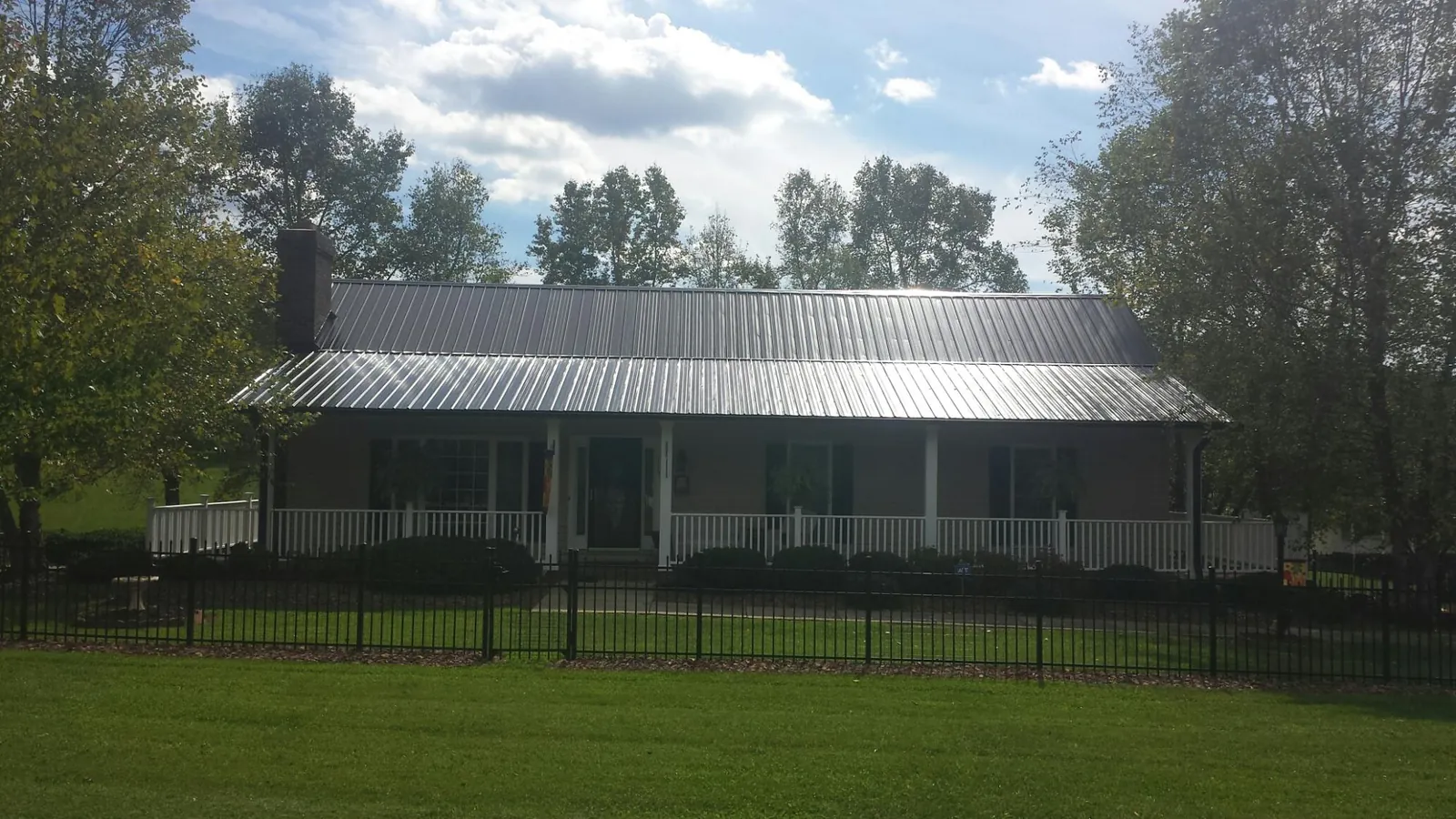 Gray metal roof on a brick ranch with a full width front porch — Gutter Guard Installation work by our crew in Boyertown